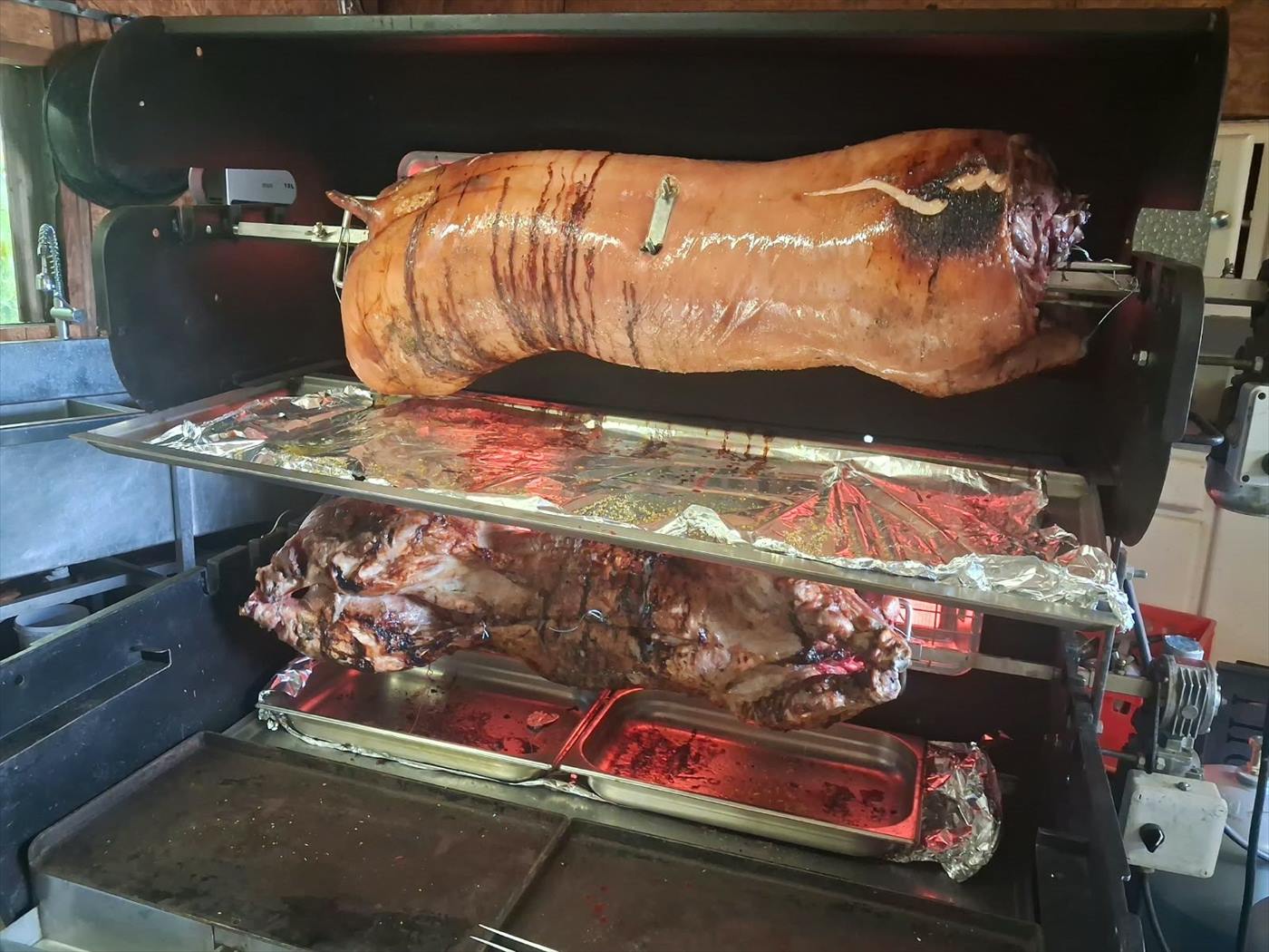 Agneau et cochon cuisant côte à côte sur la broche